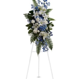 Tall white and blue floral standing spray on an easel