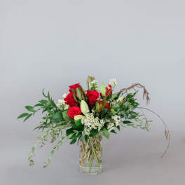 Red roses and white lilies in a clear glass vase