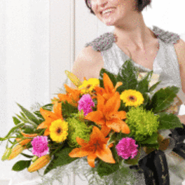 Woman holding a bright bouquet of orange lilies and yellow flowers