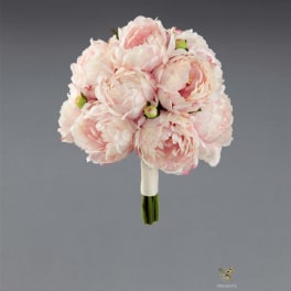 Blush pink peony bouquet with a wrapped handle on a gray background