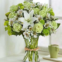 Green and white bouquet in a clear glass vase