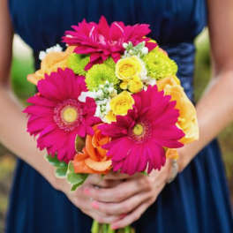 Bouquet of pink gerbera daisies, yellow roses, and orange roses