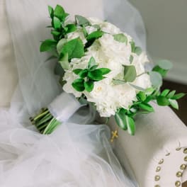White bridal bouquet with green foliage on a chair