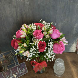 Pink and red roses with white baby's breath in a glass vase