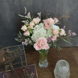 Pink roses and white hydrangeas in a clear glass vase