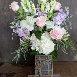 Bouquet of pink roses, white lilies, and lavender flowers in a vase