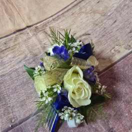 Small bouquet with white roses, blue flowers, and gold ribbon