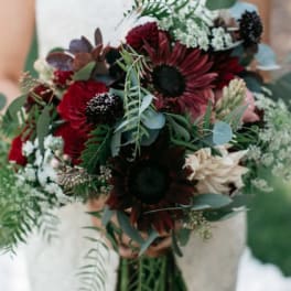 Bouquet of dark red and cream flowers with greenery