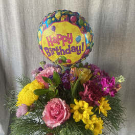 Birthday balloon above a colorful mixed flower bouquet