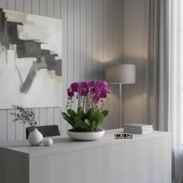 Potted purple orchids in a white bowl on a desk