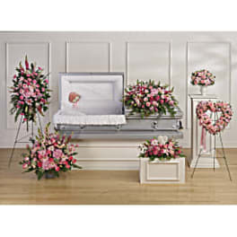 Pink floral funeral display around a white casket