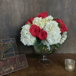 Bouquet of red roses and white hydrangeas in a glass vase