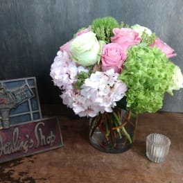 Pink and white roses with hydrangeas in a glass vase