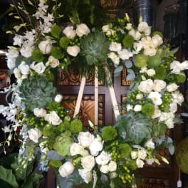 Large white floral wreath with roses and succulents on an easel