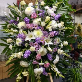 Large standing floral spray with white, pink, and purple blooms