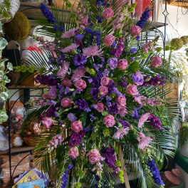 Large standing floral spray with pink and purple flowers on an easel