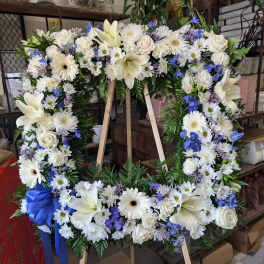 Large white and blue floral wreath on a wooden easel