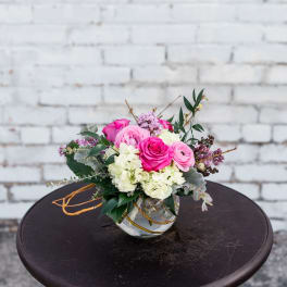 Pink and white rose bouquet in a clear glass vase