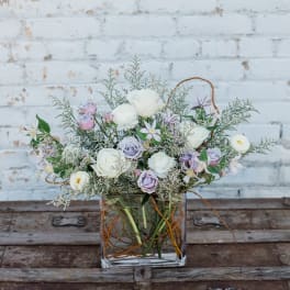 Pastel flower arrangement in a square glass vase