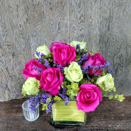 Pink and pale green roses in a square glass vase