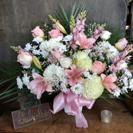 Pink and white mixed flower arrangement with a pink ribbon