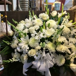 Large white floral arrangement with roses, lilies, and chrysanthemums