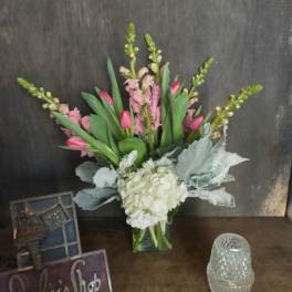 Pink tulips and white hydrangea in a clear glass vase