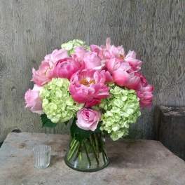 Pink peonies and green hydrangeas in a glass vase