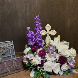 White roses and lilies with purple flowers in a low arrangement