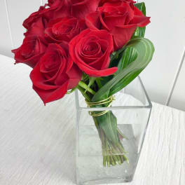 Bouquet of red roses in a clear square vase