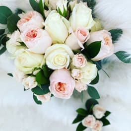 Blush and white rose bouquet with matching boutonniere on white fur