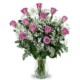 Pink roses in a clear glass vase with white baby's breath