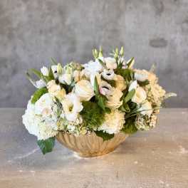White floral arrangement in a gold bowl vase