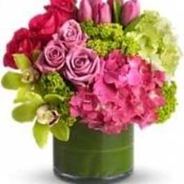 Pink and red flowers arranged in a green vase