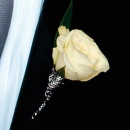 Cream rose boutonniere with a silver accent on a dark suit