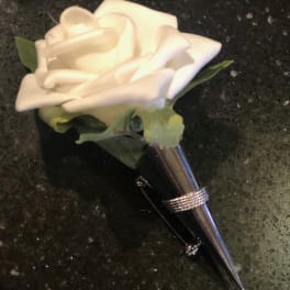 White rose boutonniere with a silver pin and cone holder