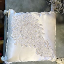 White satin decorative pillow with beaded floral embroidery and tassels