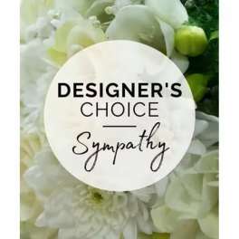 White floral sympathy arrangement with a designer's choice sign