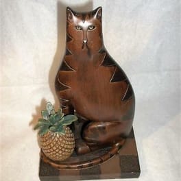 Wooden cat figurine holding a small potted succulent
