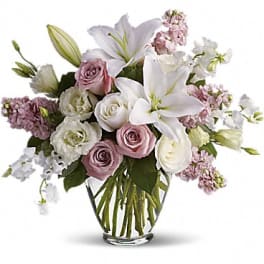 Bouquet of white lilies and pink roses in a clear glass vase