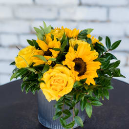 Yellow roses and sunflowers in a metal vase