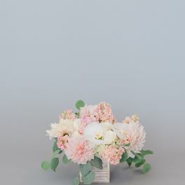 Blush and white floral arrangement in a wooden cube vase