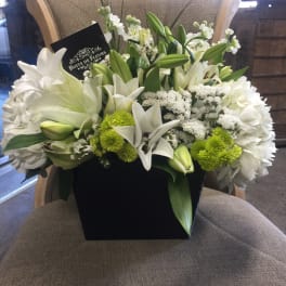 White lilies and green chrysanthemums in a black box arrangement