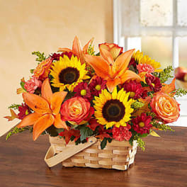 Basket arrangement with sunflowers, orange lilies, and roses