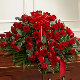 Red rose casket spray with red ribbons