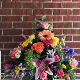 Colorful mixed flower arrangement in a metal container