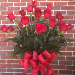 Tall bouquet of red roses with a large red ribbon