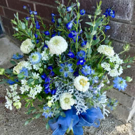Blue and white mixed flower arrangement with ribbon at the base