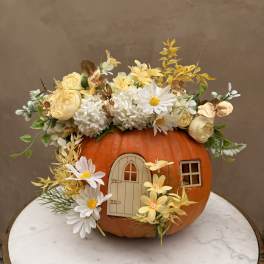 Pumpkin decorated with white and yellow flowers and a small door cutout