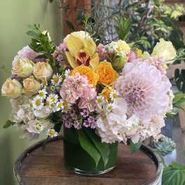 Mixed pastel flower arrangement in a dark green vase